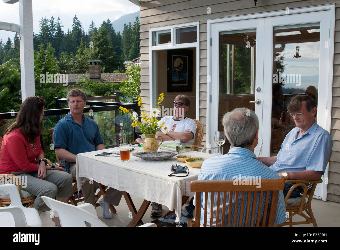 Les amis de dîner en plein air sur le patio d'accueil dans les montagnes de Vancouver, British Columbia, Canada Banque D'Images