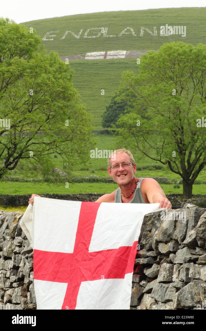 Peak District, Derbyshre, UK. 15 juin 2014. Phil Swindell (photo) du Derbyshire est le cerveau derrière un géant des illustrations sur une colline au-dessus de village Chelmorton dans le Peak District. Créé par une équipe de 15 villageois, âgé de 6 à 70 ans, le signe et d'un drapeau a pris deux jours pour compléter l'aide de 15 sacs de chaux, 10 litres de colle et peinture rouge. Résident Local, Phil, 44 ans, a déclaré que l'équipe formée d'une chaîne pour porter le lettrage de calcaire en position sur les terres appartenant à la famille près de Buxton. Chelmorton est le plus haut village du Derbyshire et l'un des plus élevés en Angleterre. © Matthew Taylor/Alamy Banque D'Images