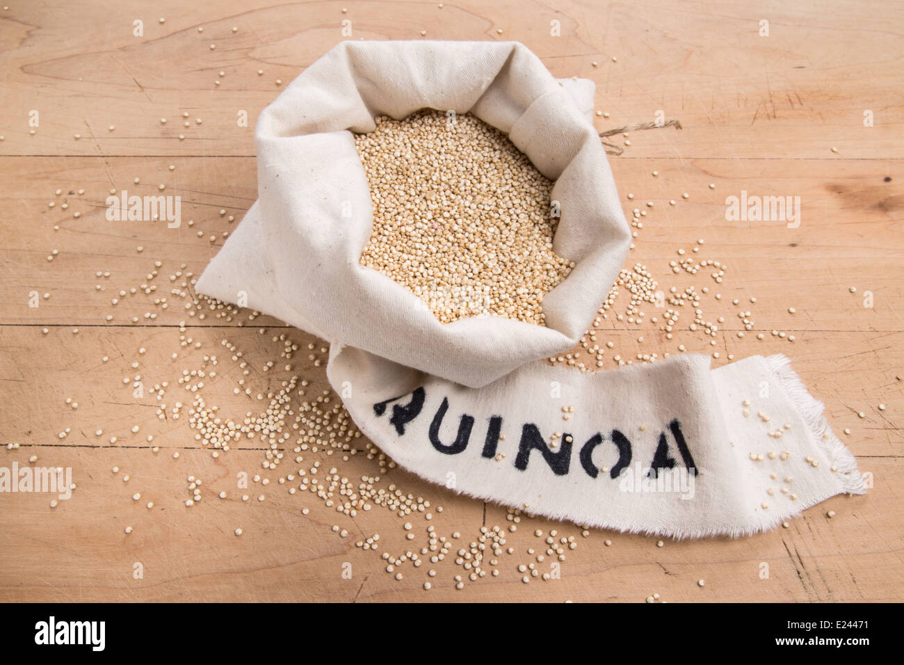 Les graines de quinoa dans un sac de crème avec une étiquette sur une planche en bois (19 de 24) Banque D'Images
