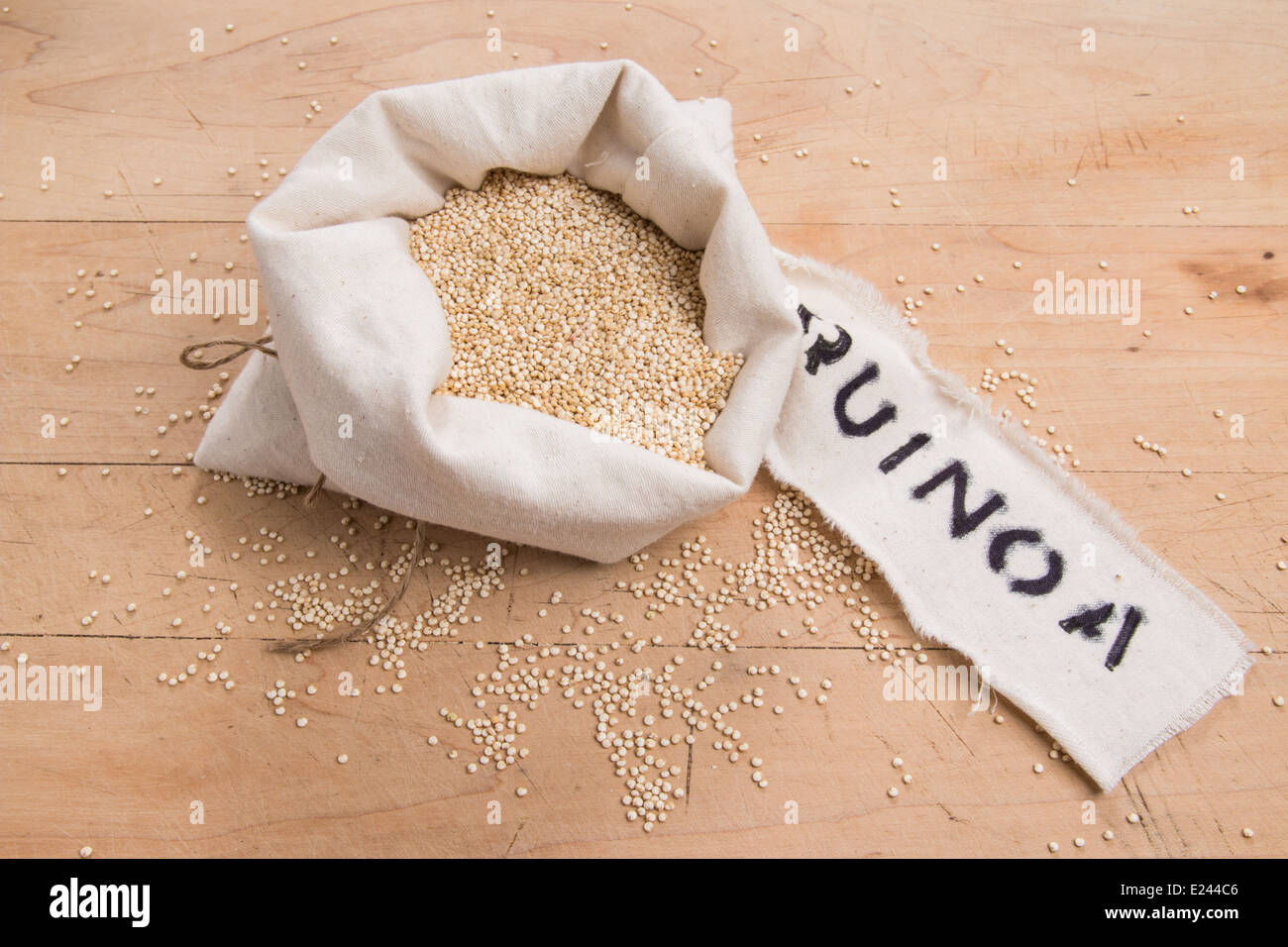 Les graines de quinoa dans un sac de crème avec une étiquette sur une planche en bois (22 de 24) Banque D'Images