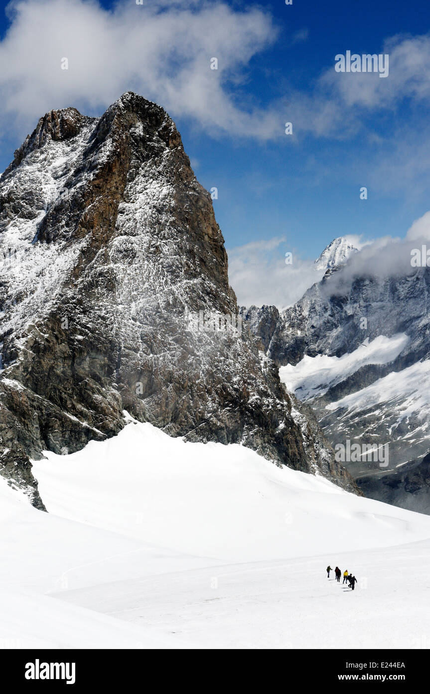 Un groupe de figures de l'alpinisme de haut sur Pigne d'Arolla près de la cabane des Vignettes dans les Alpes suisses, avec l'Eveque au-delà Banque D'Images