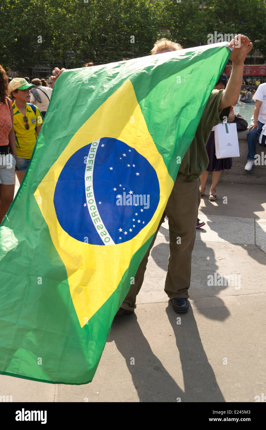 Un homme est obscurci par le drapeau brésilien il est maintenant à la fête du Brésil à Trafalgar Square, Londres. Banque D'Images