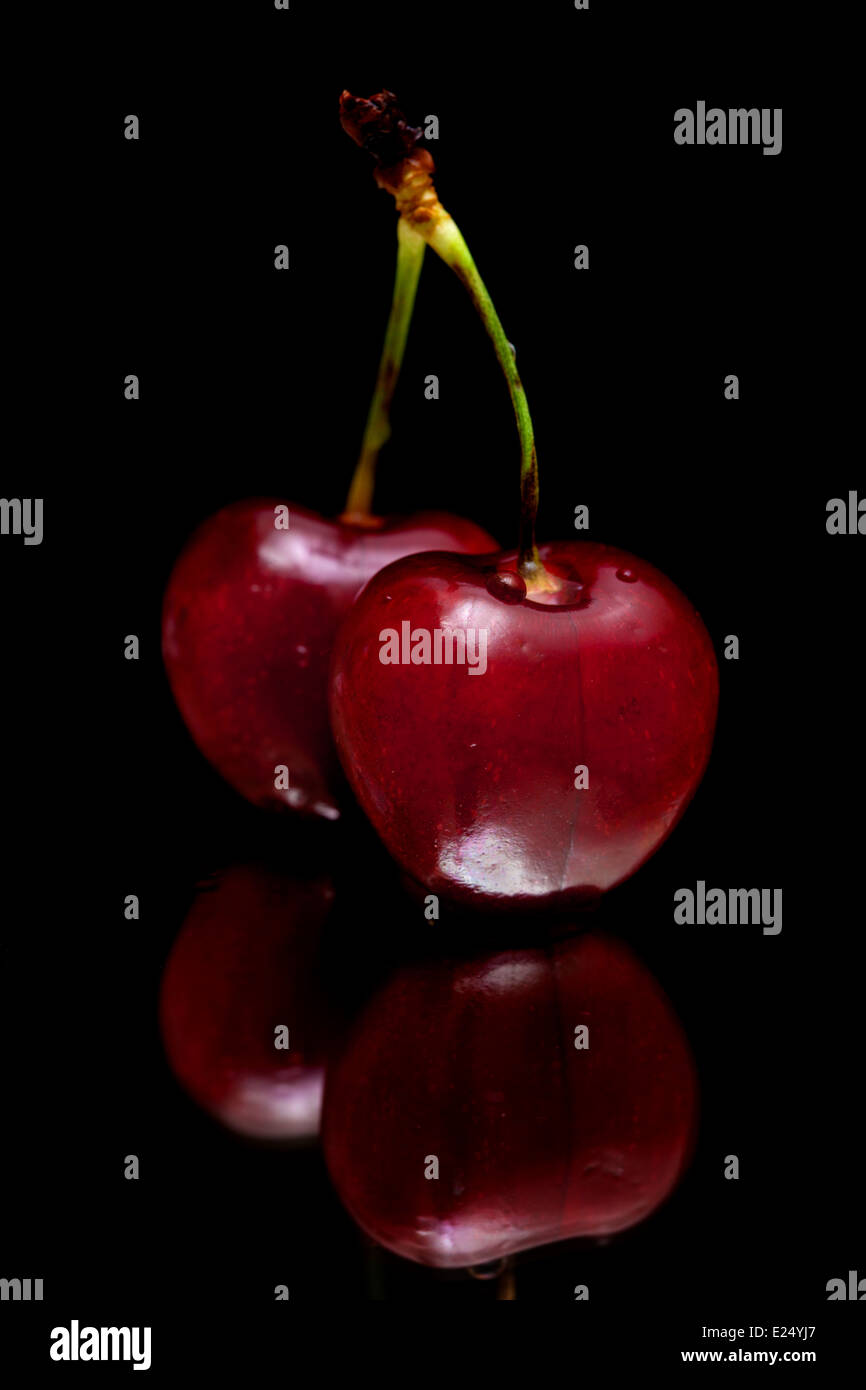 Cerises isolé sur miroir noir Banque D'Images