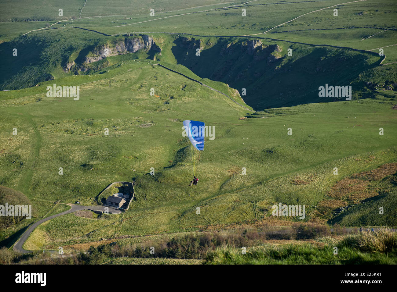 Parapente survole Treak Cliff cavern près de Castleton dans le parc national de Peak District Derbyshire, Angleterre Banque D'Images