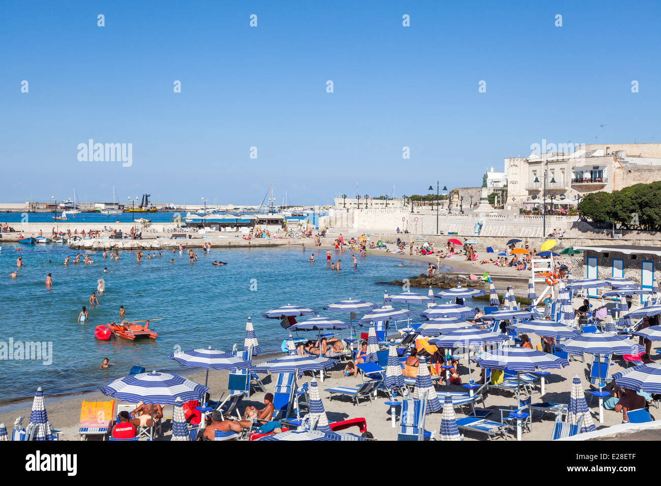 Des parasols de plage sur une plage ensoleillée en été, soleil sur la côte de Salento Otranto, Pouilles, Italie Banque D'Images