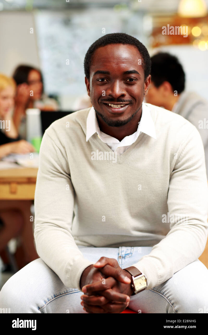 Portrait of smiling businessman assis devant des collègues Banque D'Images