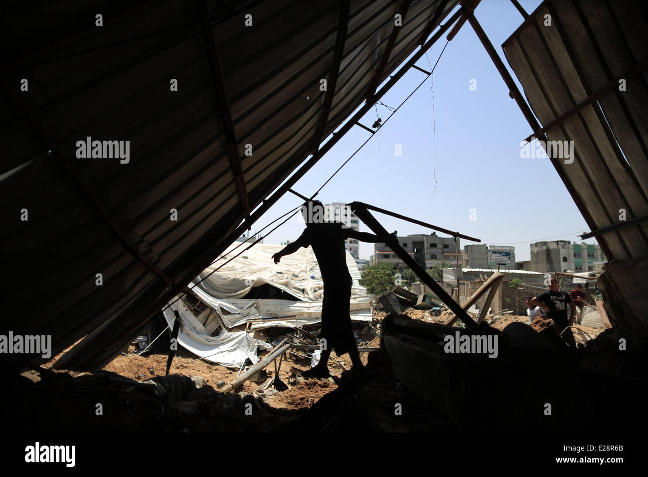 Gaza, mardi. 17 Juin, 2014. Palestiniens inspecter les débris d'un atelier métal détruit après qu'il a été atteint par une attaque aérienne israélienne à Gaza, tôt mardi, 17 juin, 2014. L'aviation israélienne a frappé un site d'activité terroriste et de deux installations de stockage d'armes nucléaires, dans le sud, le centre de la bande de Gaza, et une usine de fabrication d'armes dans le nord de Gaza, a déclaré le porte-parole de l'armée. Credit : Wissam Nassar/Xinhua/Alamy Live News Banque D'Images