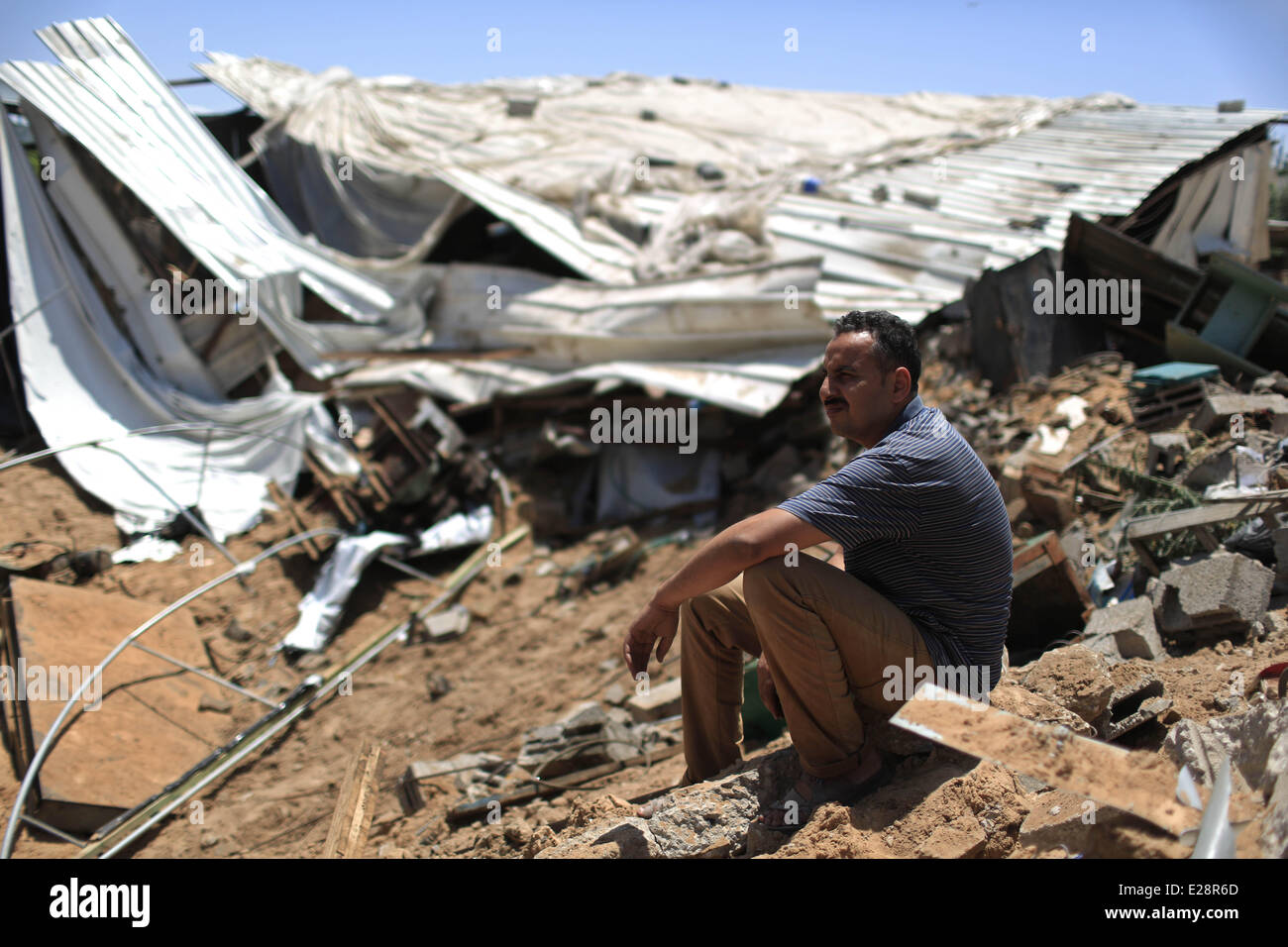 Gaza, mardi. 17 Juin, 2014. Un Palestinien se trouve sur les ruines d'un atelier métal détruit après qu'il a été atteint par une attaque aérienne israélienne à Gaza, tôt mardi, 17 juin, 2014. L'aviation israélienne a frappé un site d'activité terroriste et de deux installations de stockage d'armes nucléaires, dans le sud, le centre de la bande de Gaza, et une usine de fabrication d'armes dans le nord de Gaza, a déclaré le porte-parole de l'armée. Credit : Wissam Nassar/Xinhua/Alamy Live News Banque D'Images