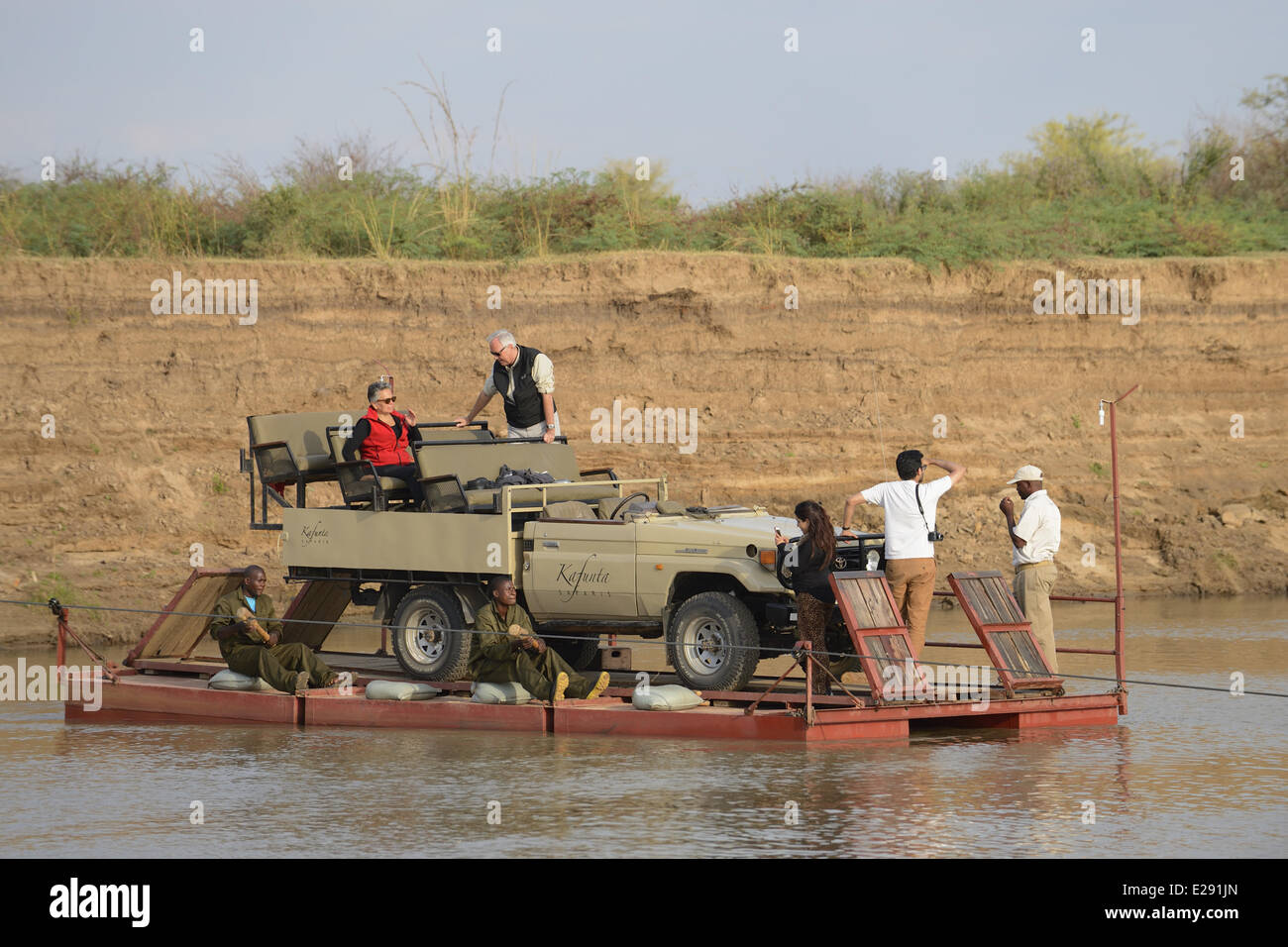 Véhicule de Safari et les touristes crossing river sur ponton, Rivière Luangwa South Luangwa, N.P., Zambie, juin Banque D'Images
