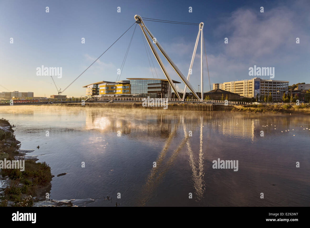 Vue sur rivière à marées avec passerelle et bâtiment universitaire au lever du soleil, Newport City passerelle, la rivière Usk, Newport, Pays de Galles, Pays de Galles, octobre Banque D'Images