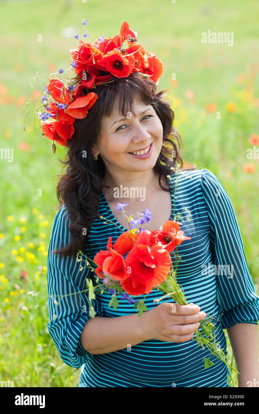 Femme dans un champ avec des fleurs de pavot. Banque D'Images