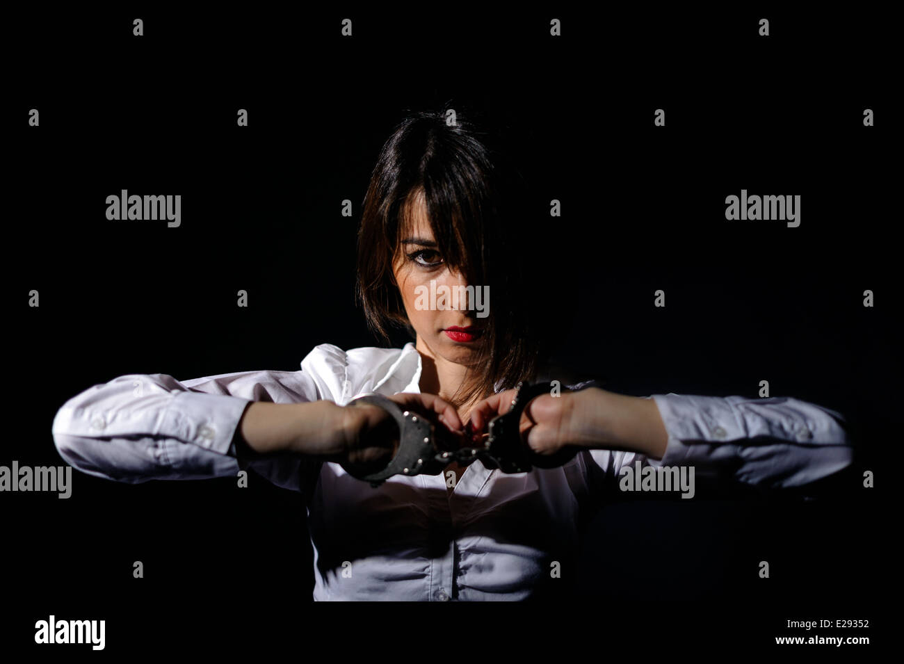Menottés arrêté girl in trouble isolé sur fond noir Banque D'Images