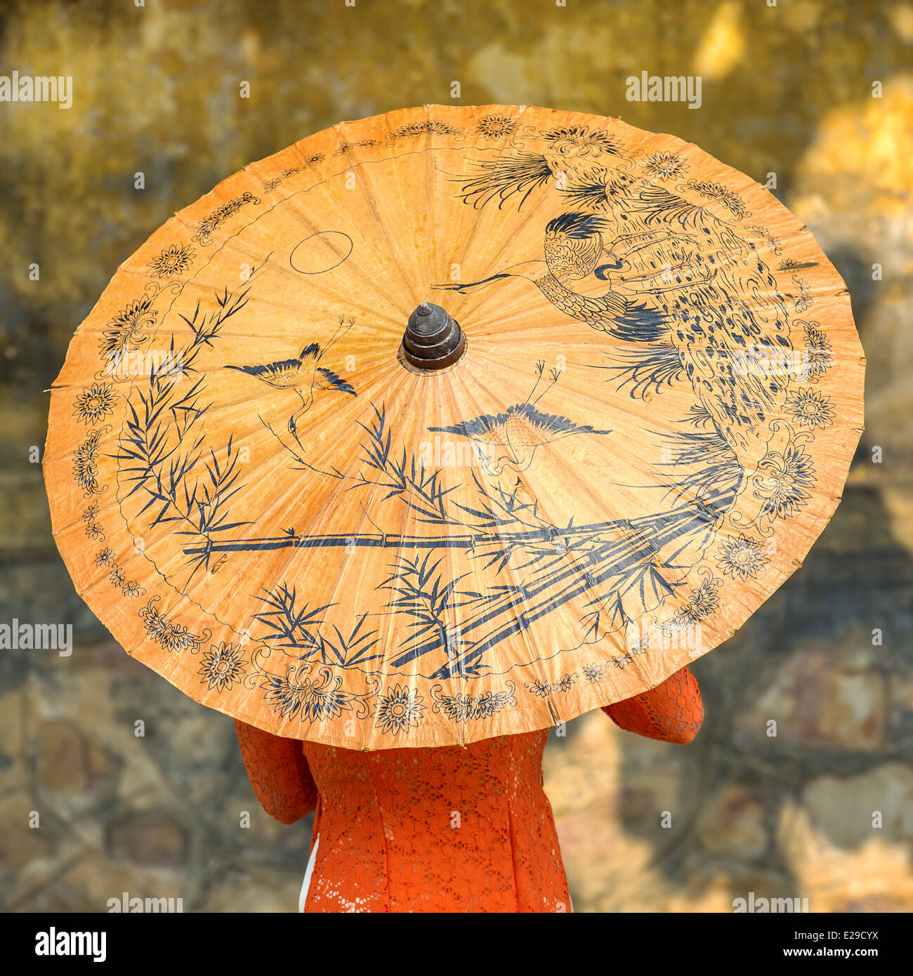 Femme portant des vêtements traditionnels vietnamiens avec parapluie de papier jaune Banque D'Images