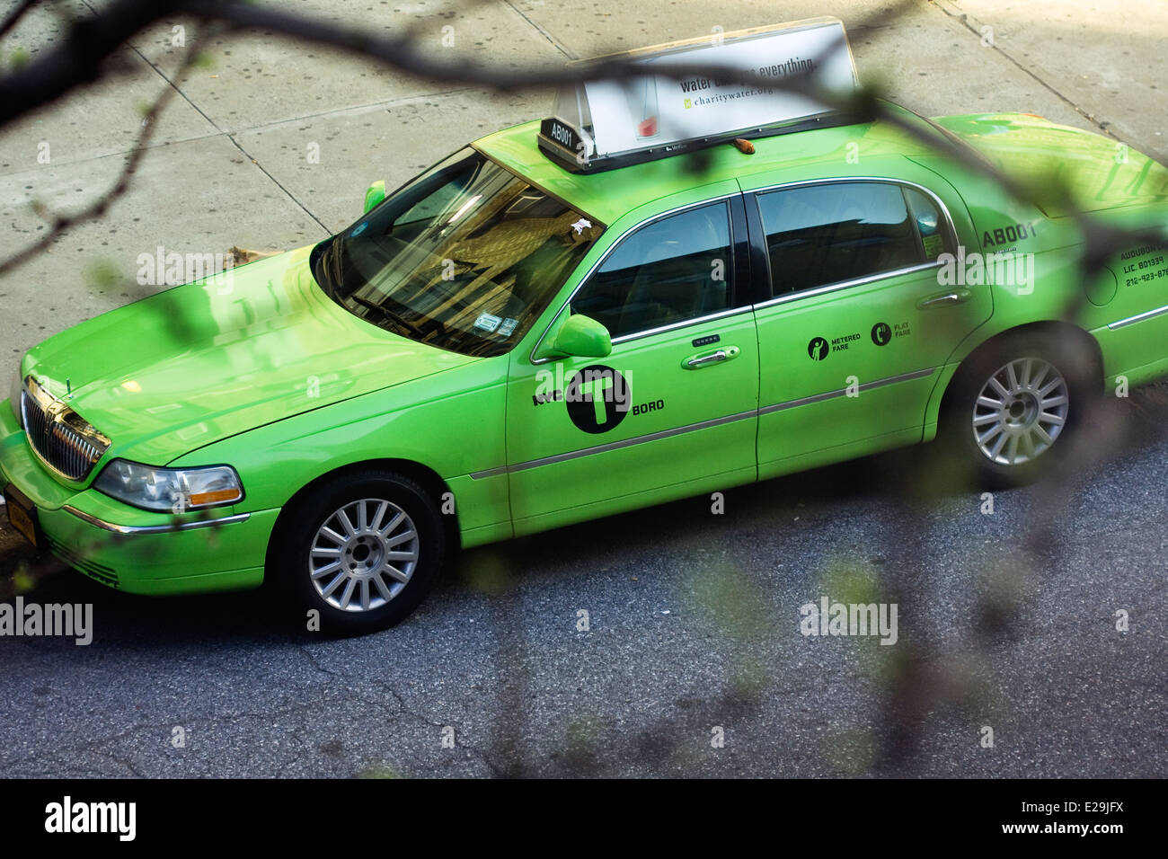 Une porte quatre Lincoln Town Car Signature Series Sedan converti en New York City Green Taxi est stationné en bordure de Manhattan Banque D'Images