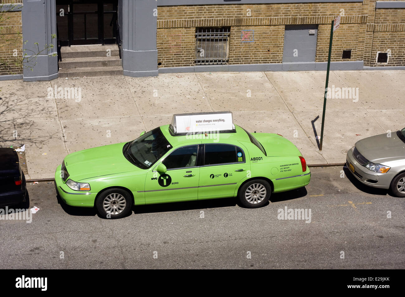 Une porte quatre Lincoln Town Car Signature Series Sedan converti en New York City Green Taxi est stationné en bordure de Manhattan Banque D'Images