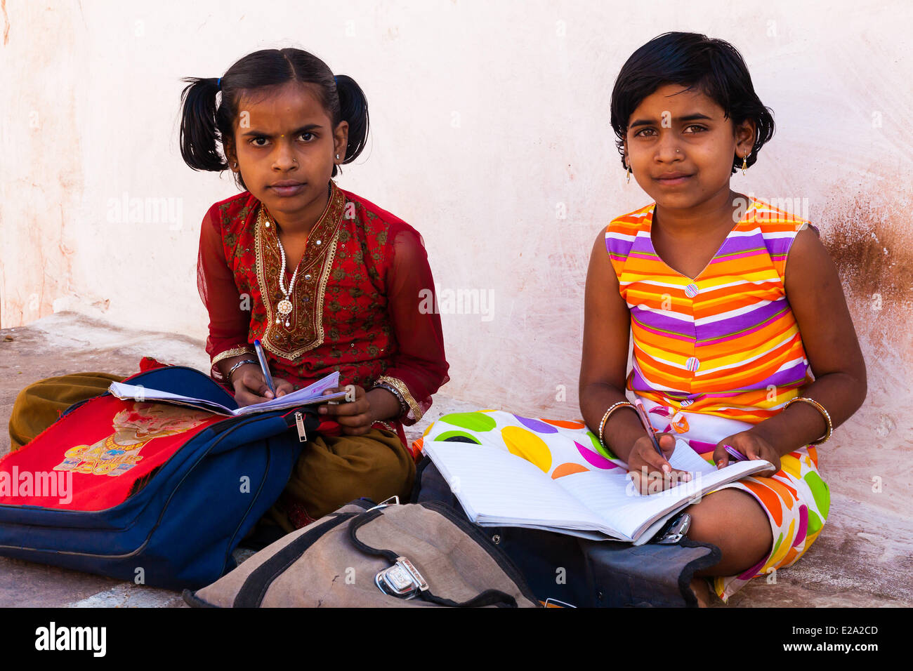 L'Inde, l'état du Karnataka, Badami, deux filles de l'école de faire leurs leçons Banque D'Images