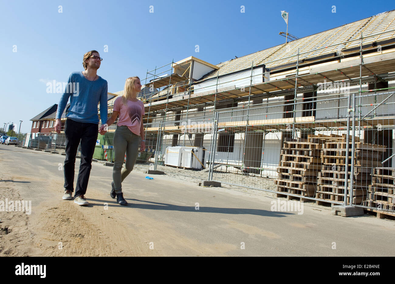 Jeune couple est de marcher à travers la rue où leur nouvelle maison est en cours de construction Banque D'Images