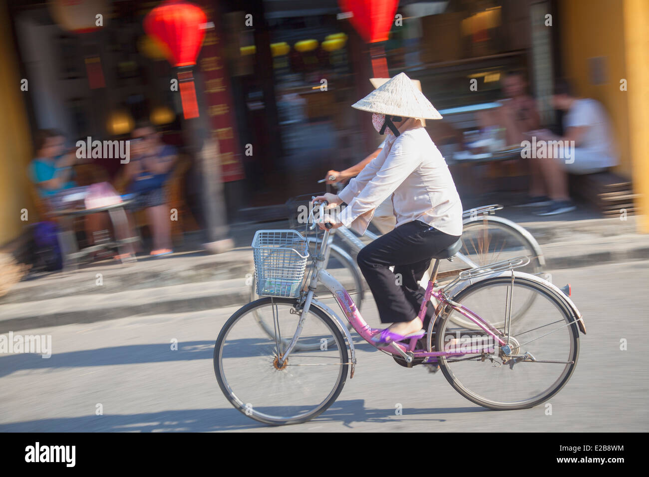 Vélo femme passé cafe, Hoi An (Site du patrimoine mondial de l'UNESCO), Quang Jambon, Vietnam Banque D'Images