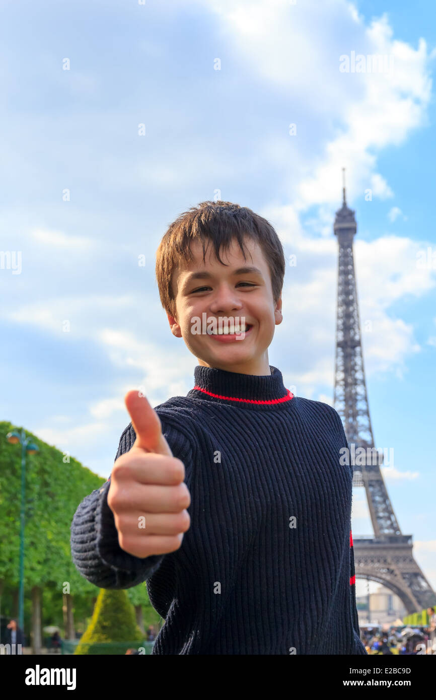 Adolescent gaie montre thumb up assise sur l'Esplanade des Invalides à Paris , France Banque D'Images