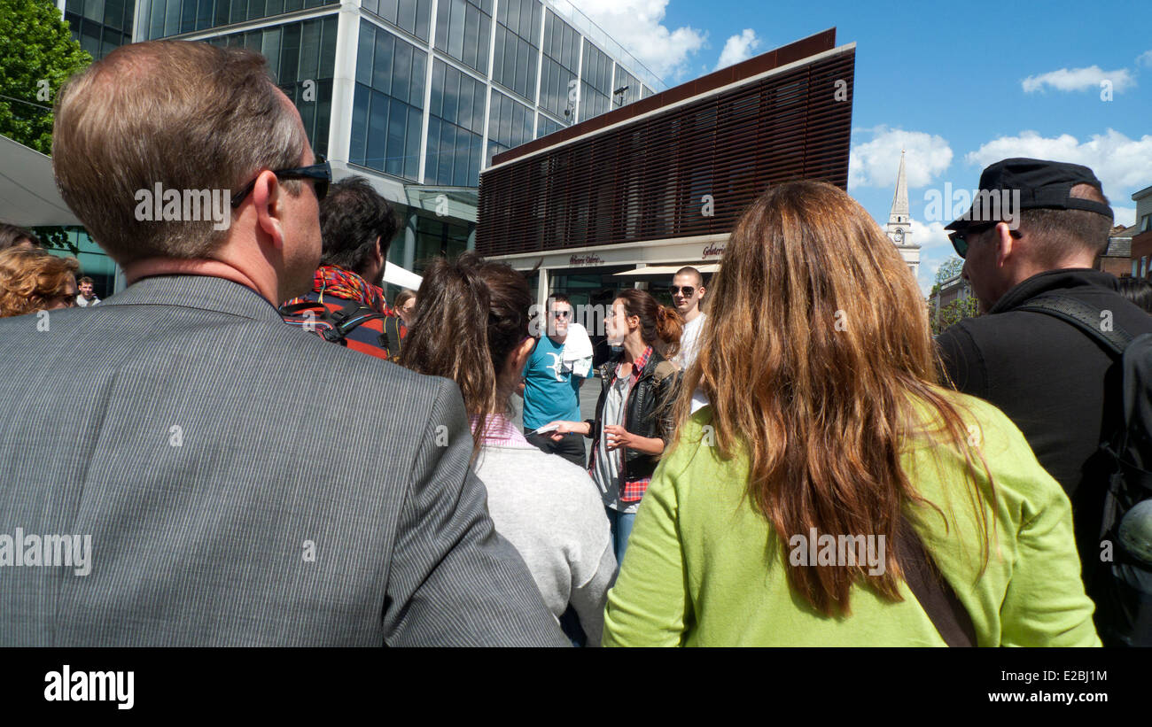 Un jeune guide touristique de dire à un groupe de touristes américains à propos de street art à Spitalfields, East London Shoreditch KATHY DEWITT Banque D'Images