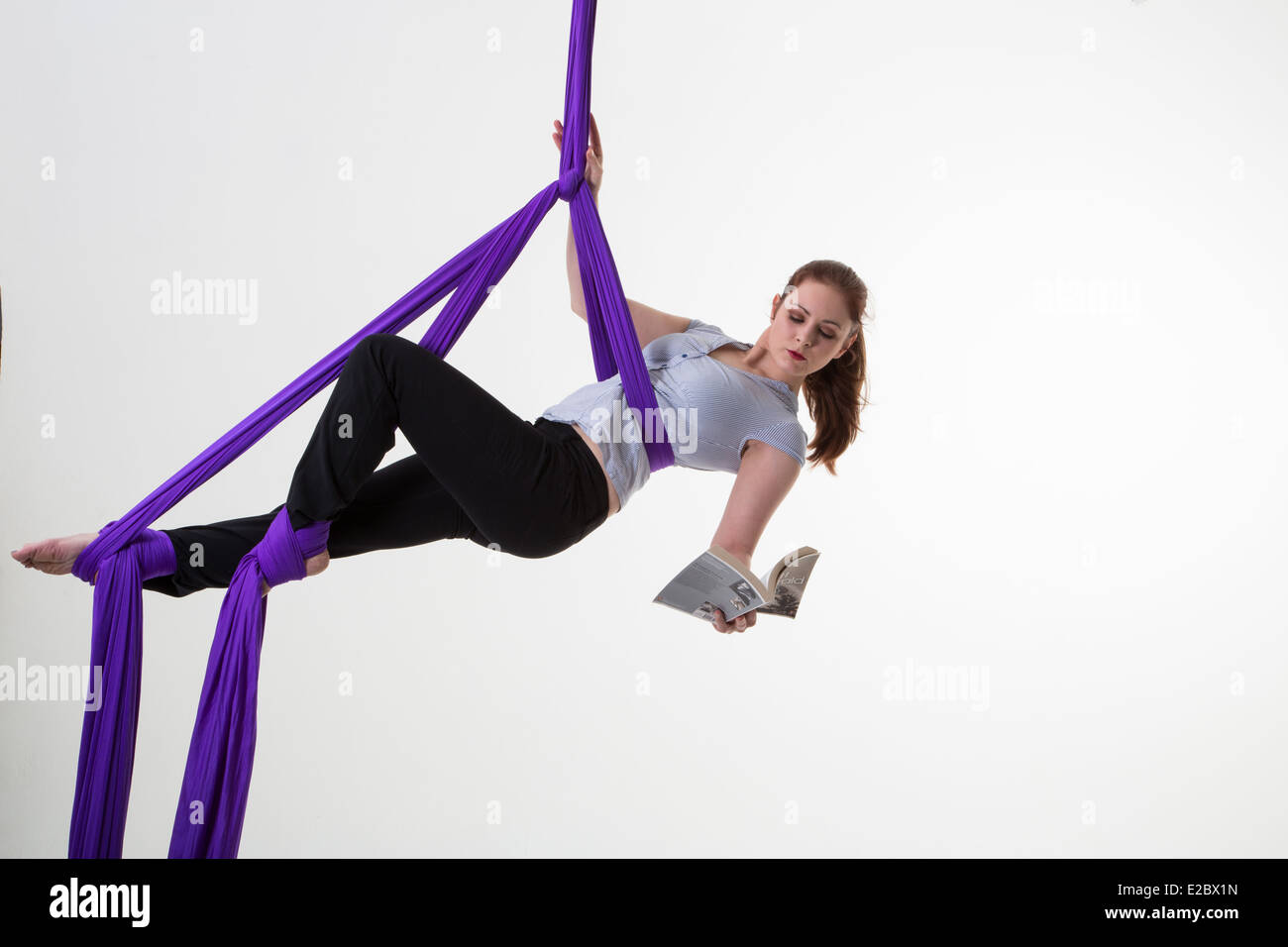 L'équilibre travail-vie femme suspendu au plafond à l'readinga book Banque D'Images