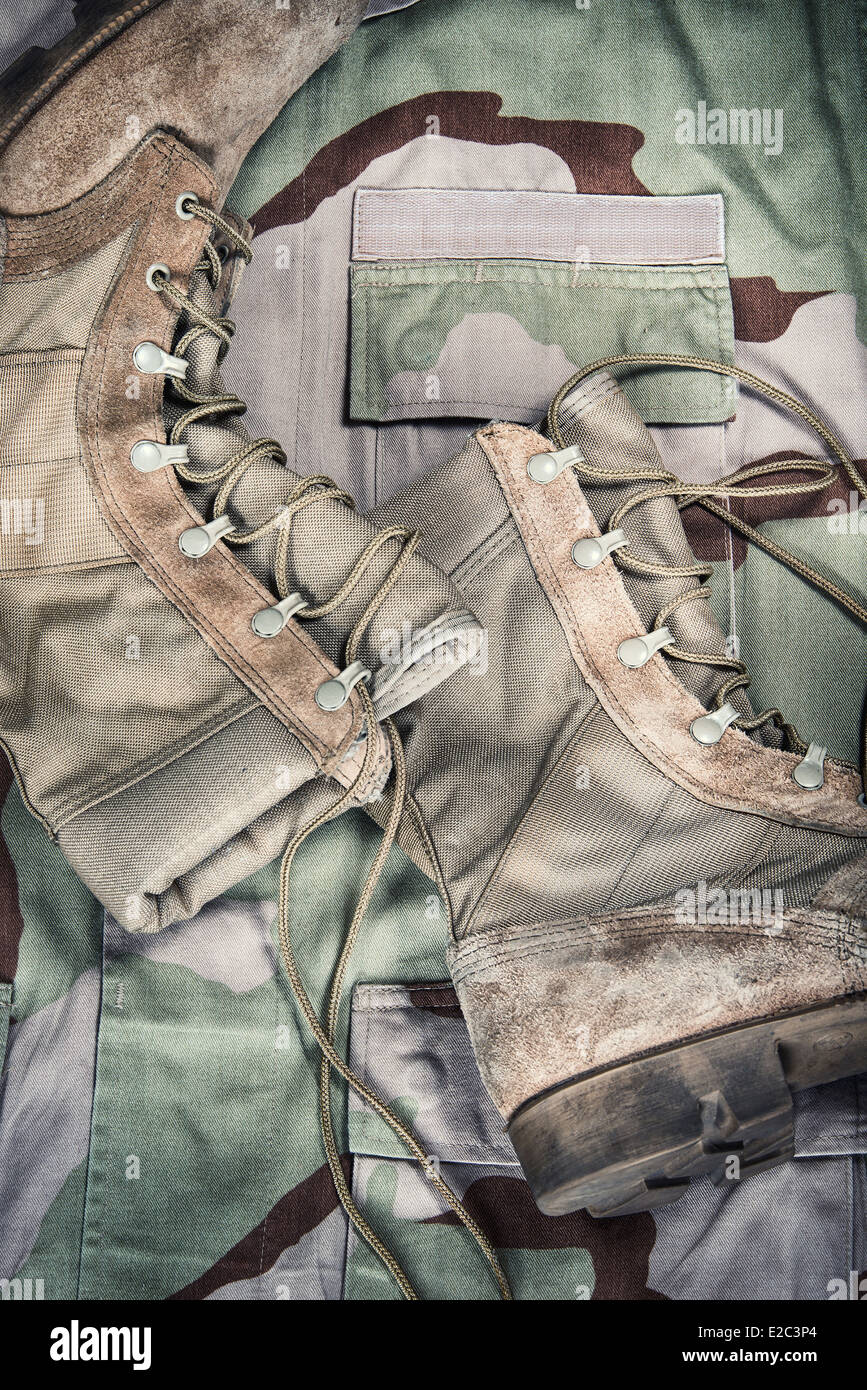 Vieilles chaussures de combat contre l'uniforme de camouflage desert Banque D'Images