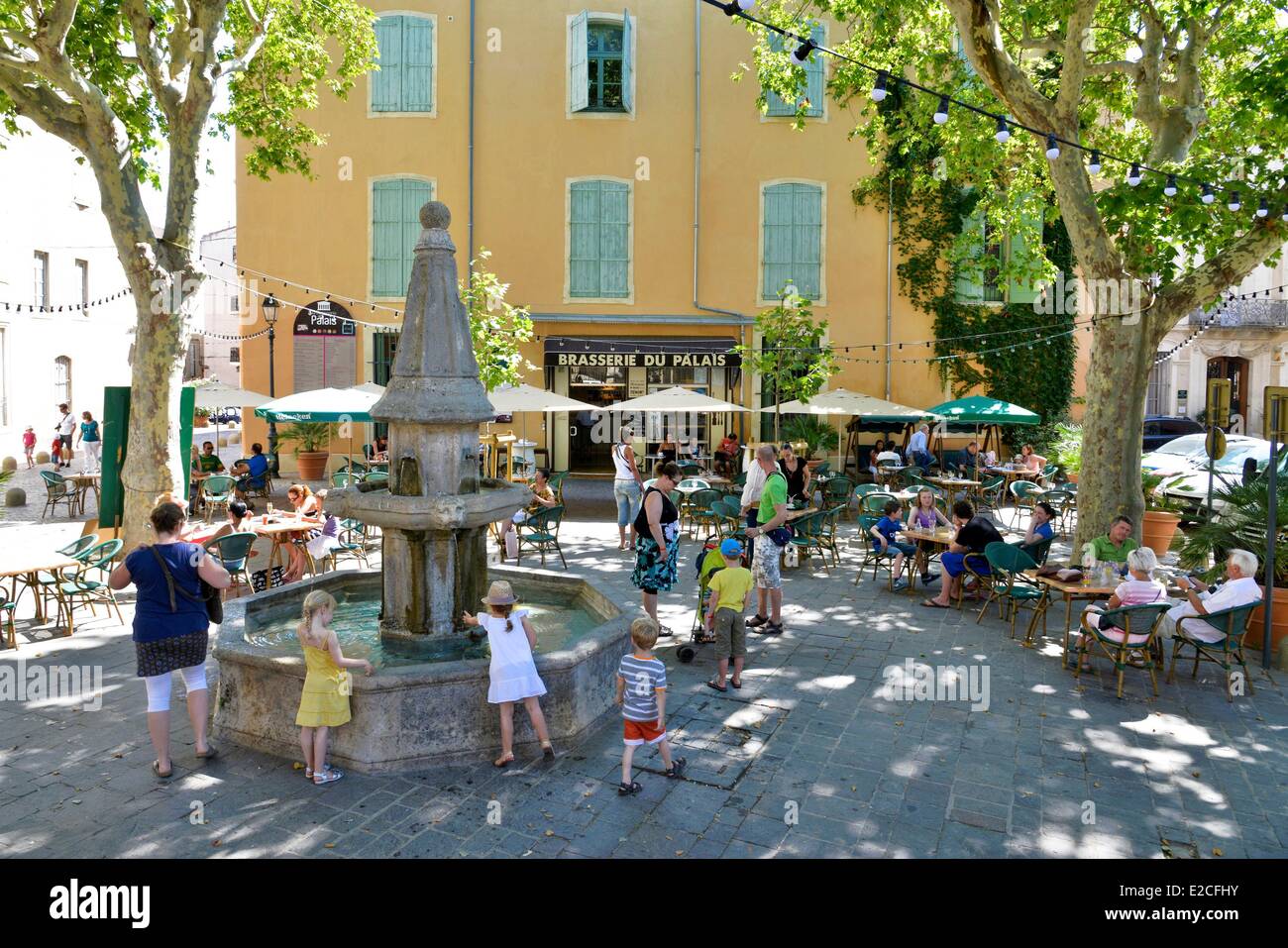 La France, l'Hérault, Béziers, place de la Révolution, terrasses de café autour d'une fontaine en pierre à l'ombre des platanes Banque D'Images