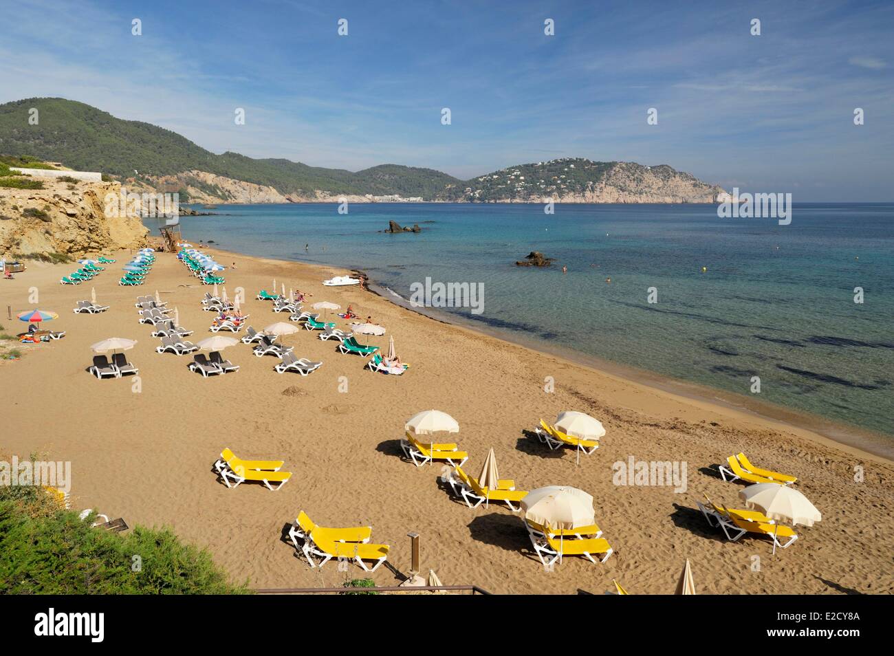 Espagne Baléares Ibiza Figueral jaune gris ou vert des chaises longues et des parasols installés sur la plage Banque D'Images