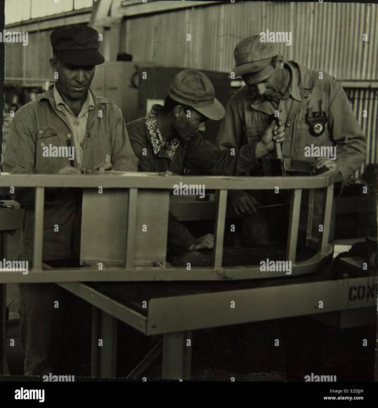 Cette image illustre les travailleurs de Convair/General Dynamics, connus pour leur rôle dans la production de technologies aérospatiales avancées au cours du XXe siècle, contribuant de manière significative à la production d’avions militaires et civils. Banque D'Images