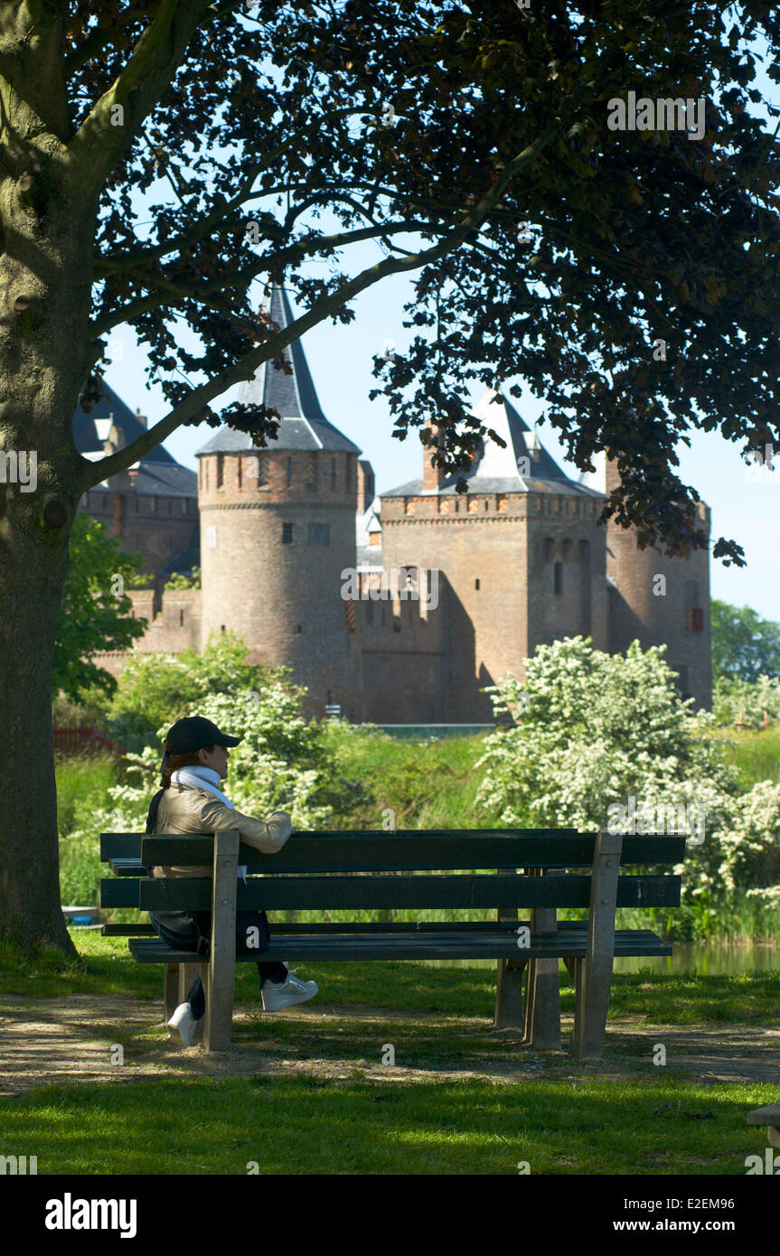 Femme de détente sur un banc avec vue sur le château Muiderslot dans Muiden, Pays-Bas Banque D'Images