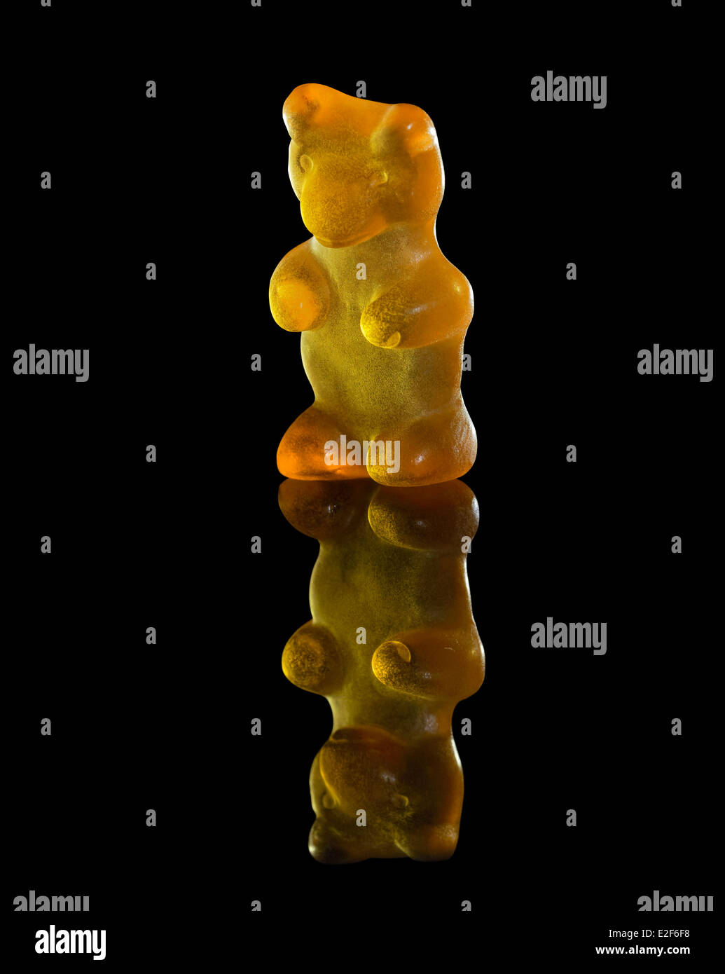 Gummy Bear translucide orange en noir arrière réfléchissant Banque D'Images