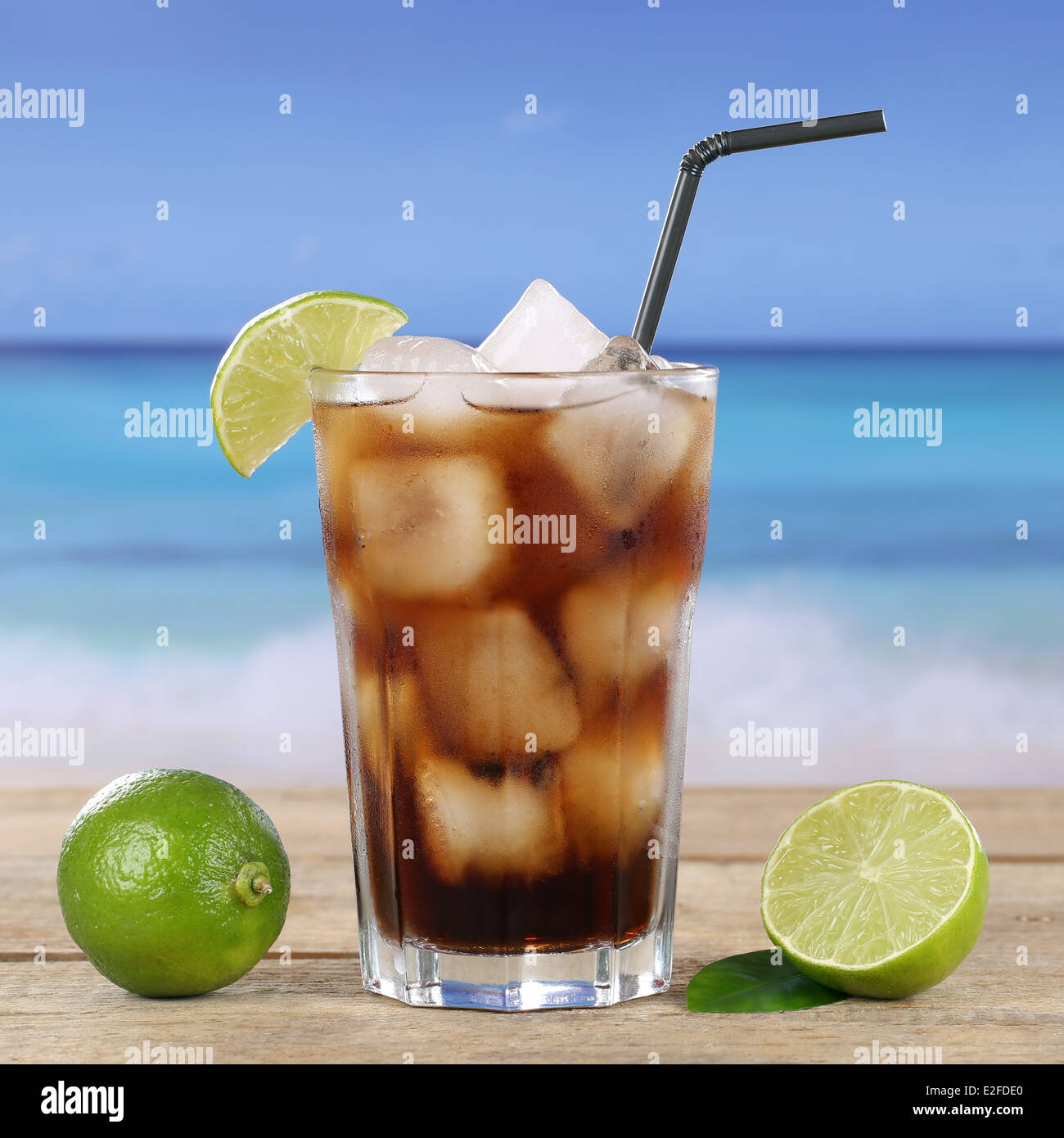 Cola ou cocktail Cuba Libre boire dans du verre, avec des cubes de glace sur la plage Banque D'Images