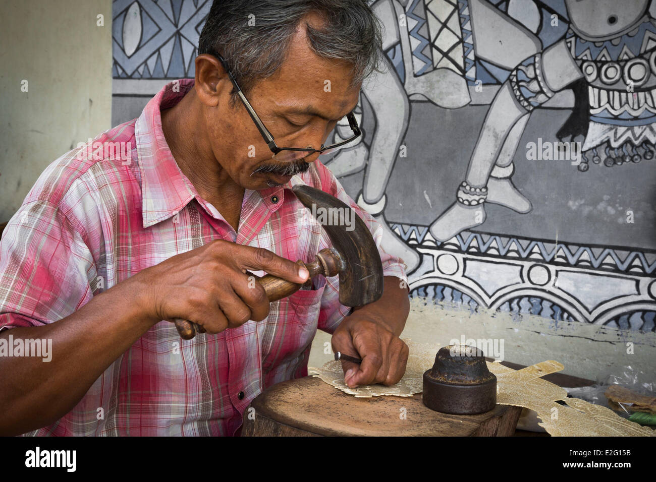 Java Indonésie Yogyakarta artisan au travail sculpter une figure en peau de bison pour la production de cuir (marionnettes Wayang Banque D'Images