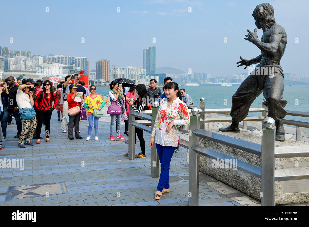 Chine Hong Kong Kowloon Avenue des Stars District touristique asiatique se faire photographier devant une statue de bronze de l'acteur Banque D'Images