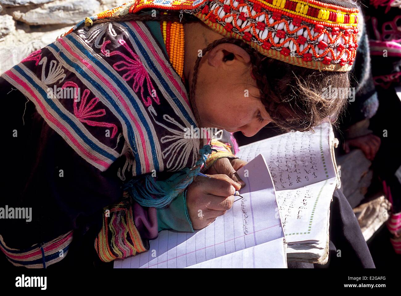 Vallées Kalash Khyber Pakhtunkhwa au Pakistan vallée peu Bumburet fille Kalash écrit en conscience à ses matériaux pédagogiques posés Banque D'Images