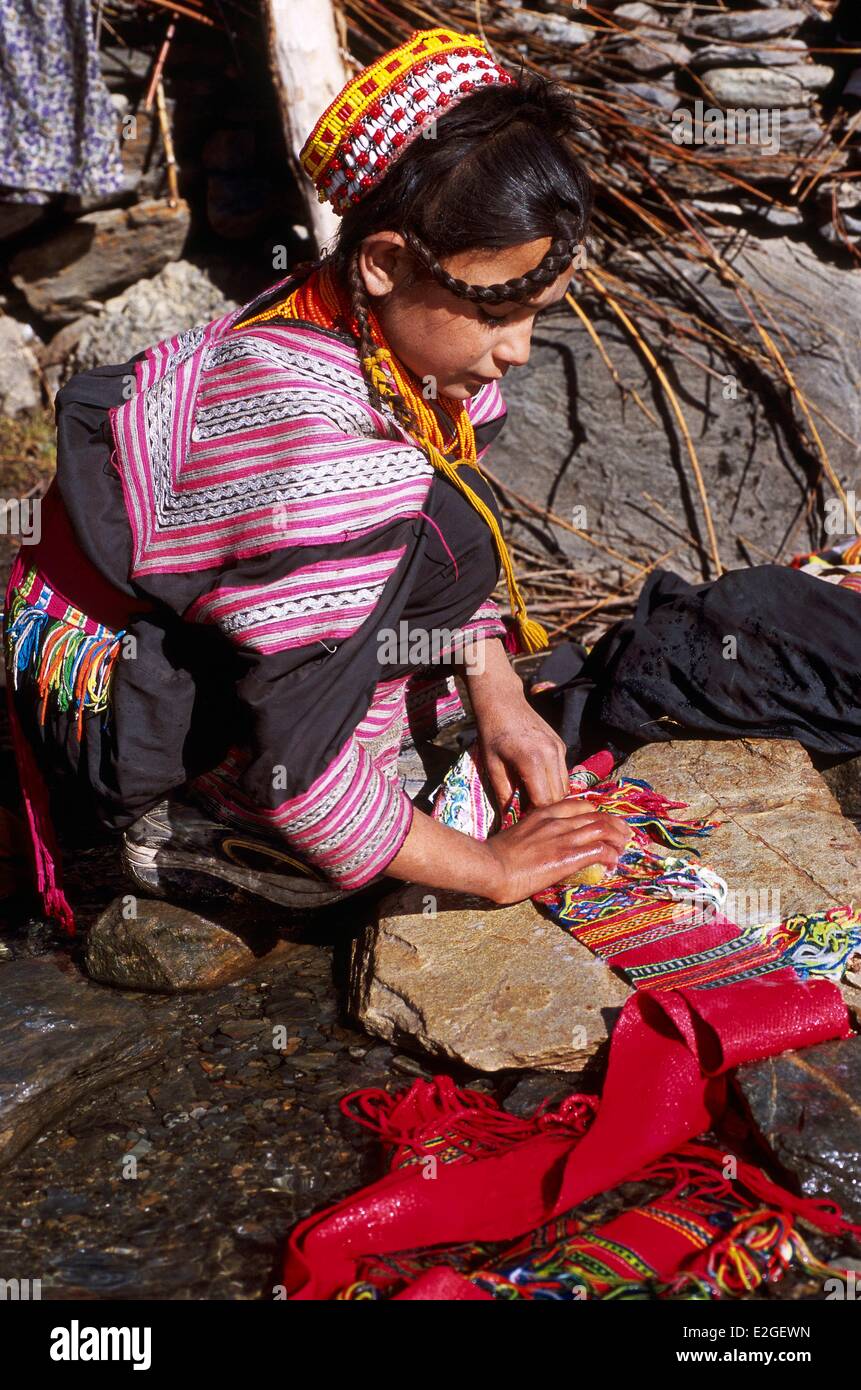 Vallées Kalash Khyber Pakhtunkhwa au Pakistan vallée Bumburet Kalash jeune fille lave-le sur une pierre d'une ceinture de laine torrent d'environ 6 mètres qui maintient et ajuste leurs robes Banque D'Images