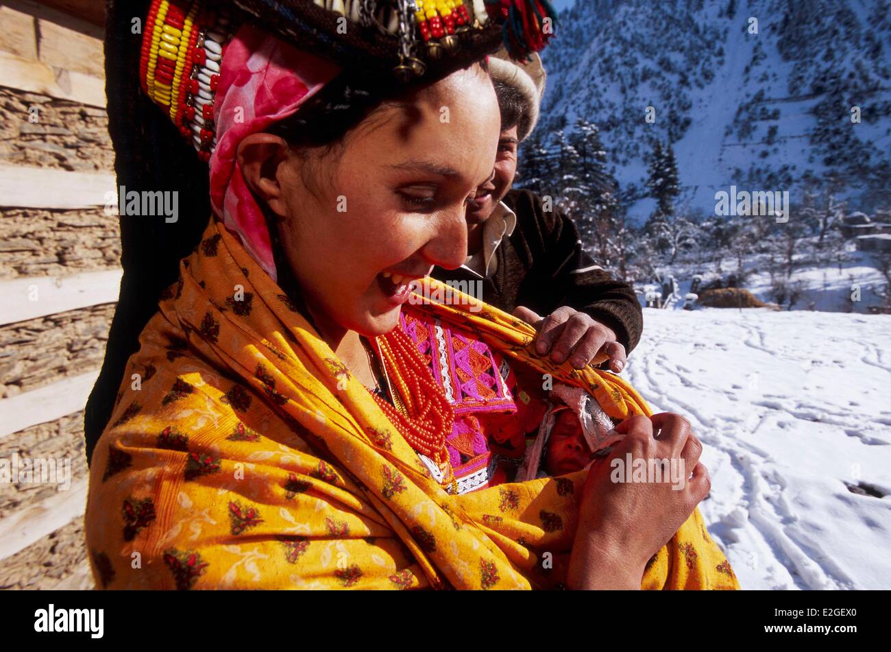 Vallées Kalash Khyber Pakhtunkhwa au Pakistan vallée Bumburet Krakal village (2150m) jeune couple présentant leur nouveau-né père répond à son enfant le 10e jour de naissance quand maman avec bébé sortir Bashali maison isolée pour les femmes menstruées et naissances Banque D'Images