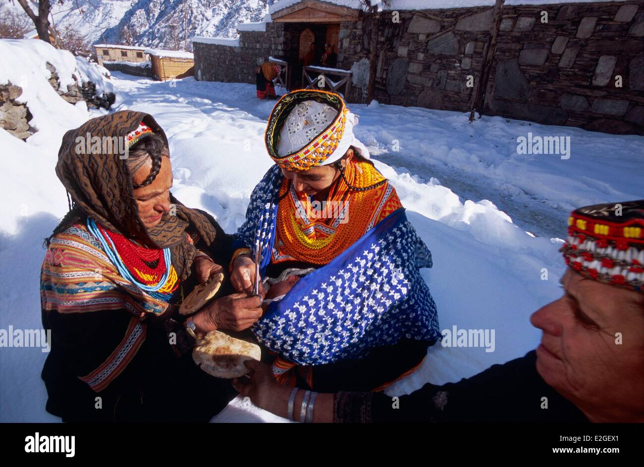 Vallées Kalash Khyber Pakhtunkhwa au Pakistan vallée Bumburet Krakal village (2150m), jeune mère de présenter son bébé au 10e jour après la naissance pour femmes ménopausées de clan qui lui purifiée en coupant une mèche de cheveux dans le trou du pain pur pattie placé Banque D'Images
