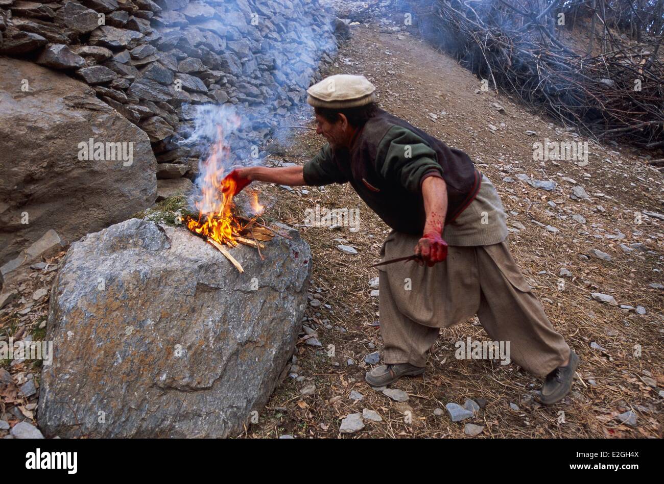 Vallées Kalash Khyber Pakhtunkhwa au Pakistan vallée Bumburet sacrificateur de jeter dans les flammes du feu sacré une partie de sang d'animaux sacrifiés offert aux fées ni dieux sollicité Banque D'Images