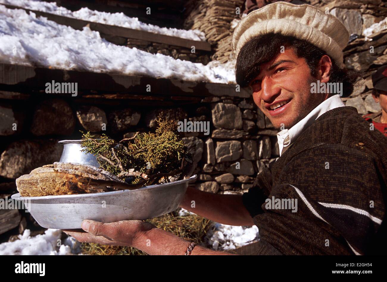 Le Pakistan Khyber Pakhtunkhwa vallées Kalash Kalash valley Bumburet homme tenant dans ses mains le pain et l'eau de genièvre trois éléments sacrés de nombreux rites païens que le rythme des fêtes festival du solstice d'hiver Chaumos Banque D'Images