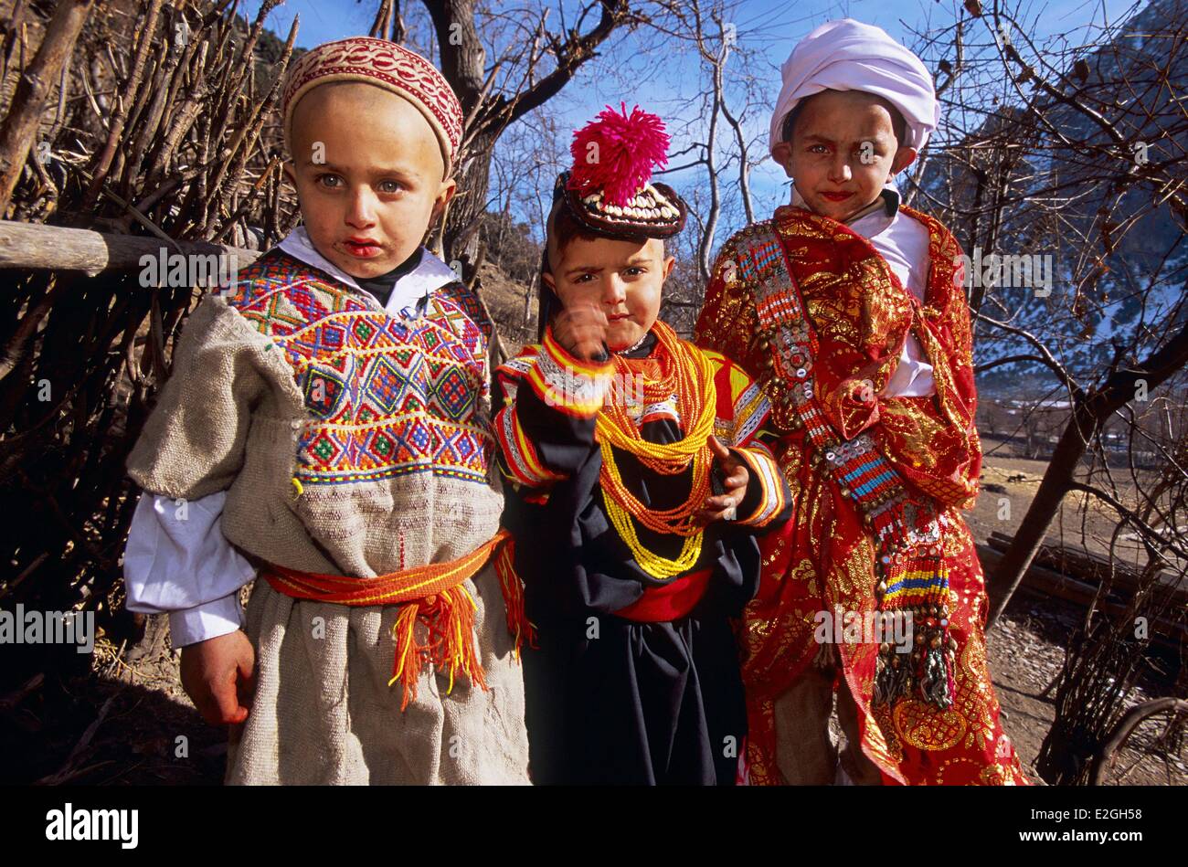 Vallées Kalash Khyber Pakhtunkhwa au Pakistan Bumburet valley petit 4 ans, fille, couverts de sa première robe et chapeau entouré par deux jeunes garçons de 7 ans habillé en berger et guerrier Kalash après leurs rituels initiatiques de mais Sambiak et Tchelik S Banque D'Images
