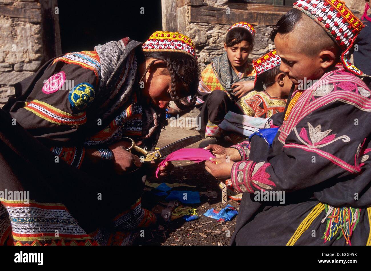 Vallées Kalash Khyber Pakhtunkhwa au Pakistan vallée Bumburet jeunes filles le découpage en morceaux de tissu pour faire de petites poupées de chiffons pour rituel de jour Gambahutiak rite d'exorcisme poupées fermer trois semaines des festivités du festival du solstice d'hiver Chaumos Banque D'Images