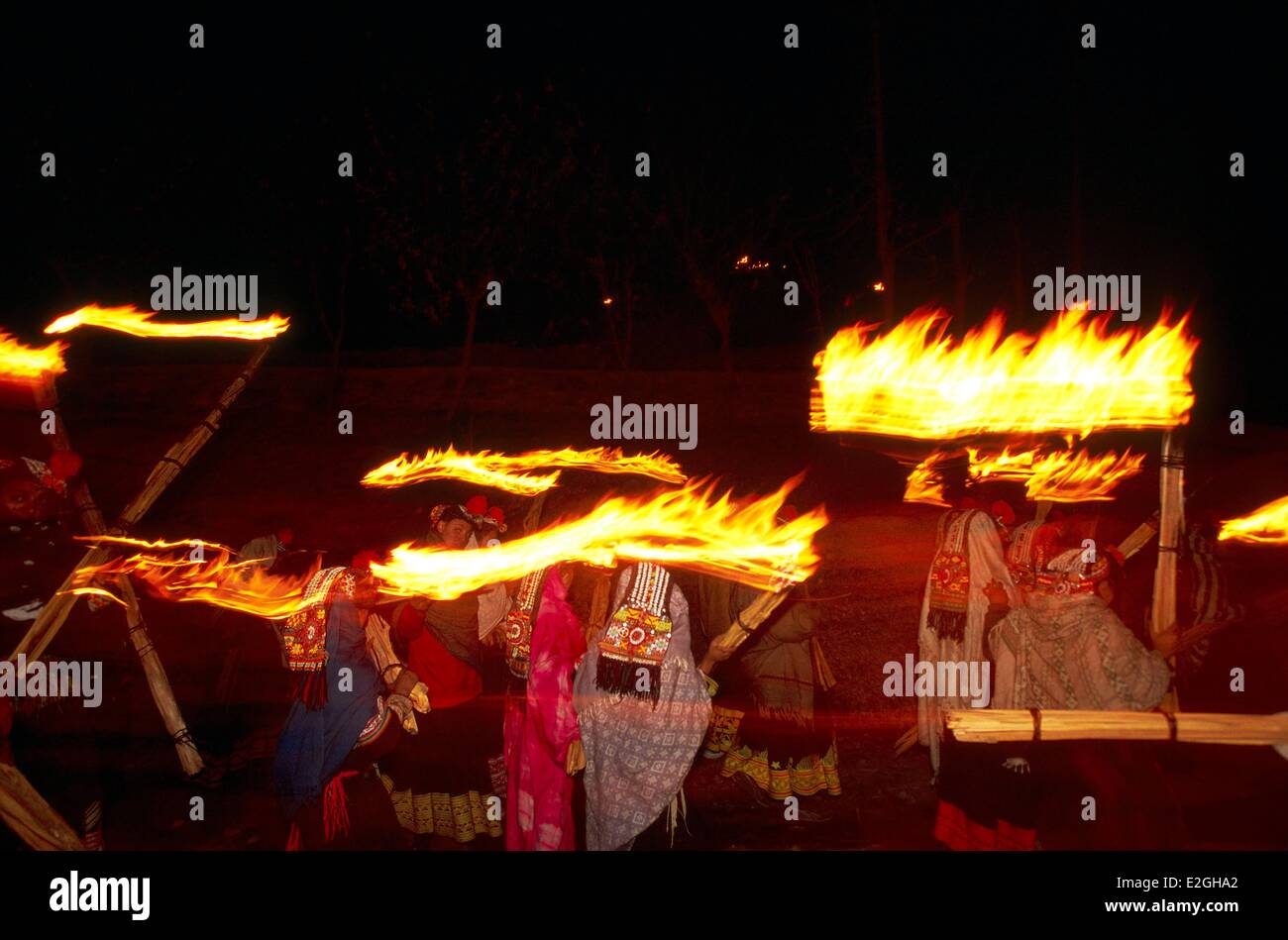 Le Pakistan Khyber Pakhtunkhwa vallées Kalash Kalash valley Bumburet Femmes marchant en procession dans la nuit noir allumé torches géantes de rituel Shanjarat nuit du ballet de lumières lumières censé montrer réunion laïque place à Balumein Kalash prestigieux Banque D'Images
