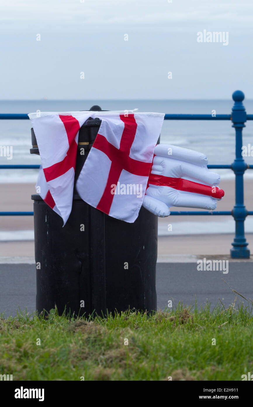 Drapeaux de l'Angleterre (Saint George's cross) et dans la main gonflable sur corbeille beach. UK Banque D'Images