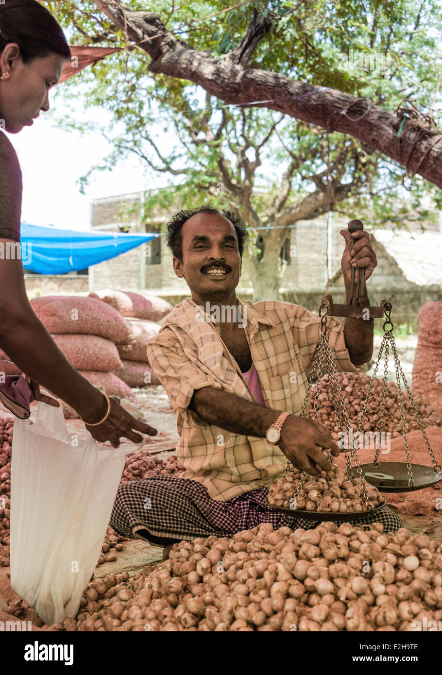 Cheerful vendeur holding balances, marché indien, Chinnamanur, Tamil Nadu, Inde Banque D'Images