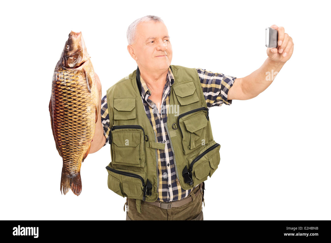 Pêcheur mature tenant un poisson et prendre des selfies Banque D'Images