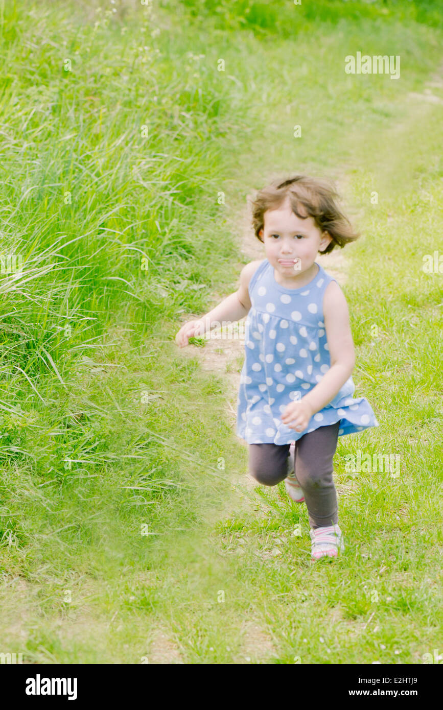 Petite fille en marche sur le chemin dans la campagne Banque D'Images