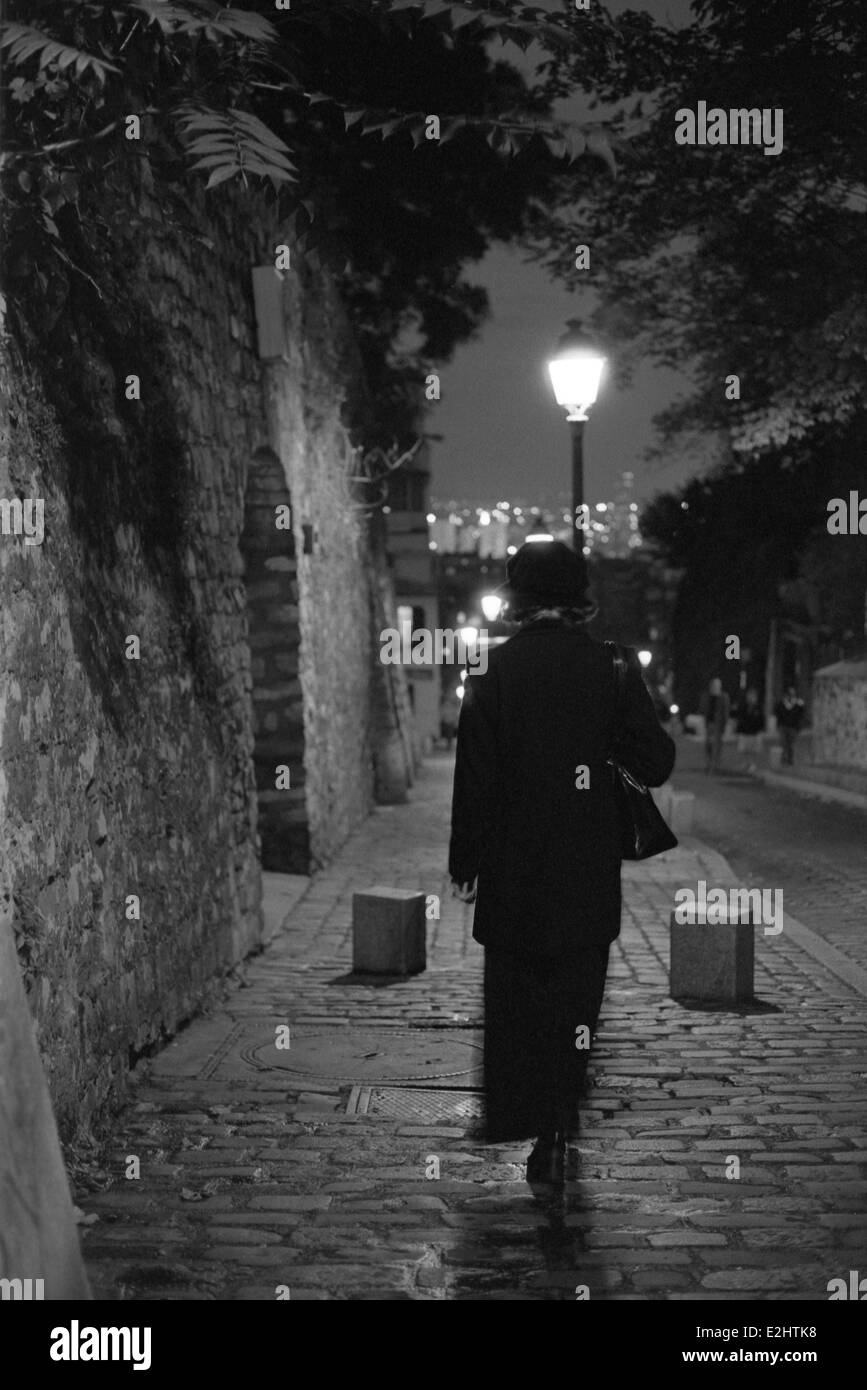 Femme de marcher seul la nuit sur le trottoir vers le bas Banque D'Images