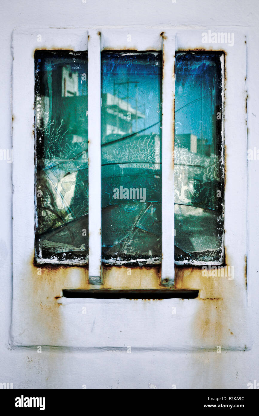 Réflexions sur une fenêtre fissurée dans un village sicilien Banque D'Images