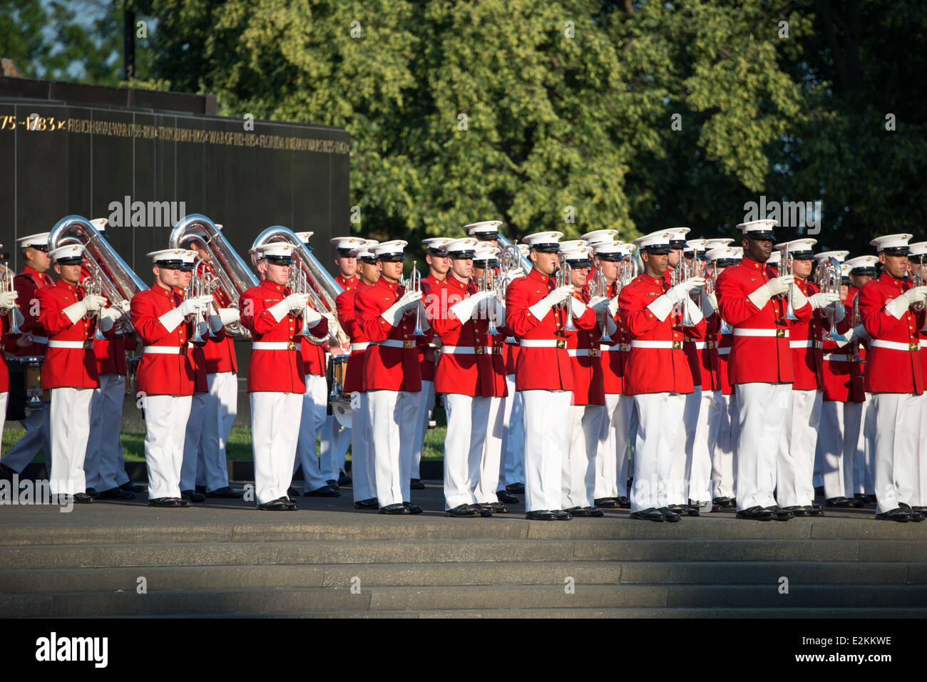 United States Marine Drum and Bugle corps Arlington Virginia // ARLINGTON, Virginia — les membres du United States Marine Drum and Bugle corps, « The commandant's Own », jouent lors de la Sunset Parade au Marine corps War Memorial. L'unité musicale d'élite, créée en 1934, effectue des mouvements de forage de précision tout en jouant de la musique martiale traditionnelle. Le mémorial emblématique, représentant le lever du drapeau à Iwo Jima, sert de toile de fond spectaculaire pour ces cérémonies hebdomadaires d'été qui ont lieu le mardi soir. Les performances mettent en valeur la précision du corps des Marines et l'aspect militaire pour le public de Banque D'Images